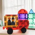 Orange and yellow magnetic tile truck on a TileTek car base with peg dolls seated inside