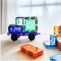 Purple and green TileTek magnetic tile truck beside loose L-shaped and rectangle tiles