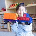 Child holding an orange and blue TileTek magnetic tile truck and trailer