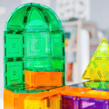 Close-up of a green TileTek magnetic tile dome build beside orange and yellow tiles