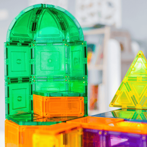 Close-up of a green TileTek magnetic tile dome build beside orange and yellow tiles