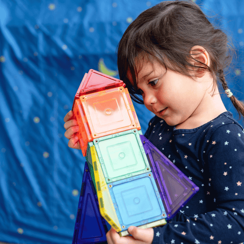 Child holding a small TileTek magnetic tile rocket built from coloured squares