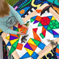 Child arranging TileTek magnetic tile triangles into a mosaic pattern outdoors