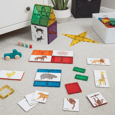 Assorted Tile Tek animal puzzle toppers beside a magnetic tile house build