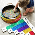 Child scooping rice beside Tile Tek numeral and dot-pattern toppers on a tile row