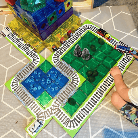 Child playing with a Tile Tek train track layout built into a lake and forest scene