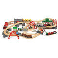 Experience the Brio World Deluxe Railway Set—an expansive, intricate wooden train set featuring diverse tracks, tunnels, bridges, and accessories. A vibrant assortment of Brio trains and vehicles travels along the tracks, navigating through scenic elements such as a station, mountains, and a cargo ship.