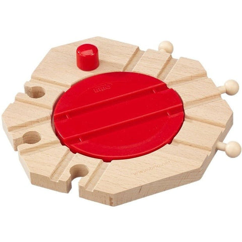 The Brio World Mechanical Turntable from Brio is a wooden toy train track accessory featuring a circular red rotating piece in the center. It has four connecting points and three wooden pegs on the sides, allowing for customization or attachment to other railway set pieces for endless fun and creativity.