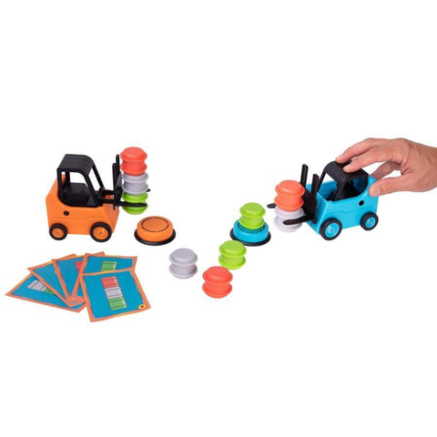 The Fat Brain Toys Forklift Frenzy by Fat Brain Toys features two toy forklifts, one orange and one blue, actively stacking vibrant discs. A hand maneuvers the blue forklift in a lively scene of bustling forklifting. With five challenge cards and a collection of colorful discs scattered around the forklifts, this toy set is excellent for honing fine motor skills.