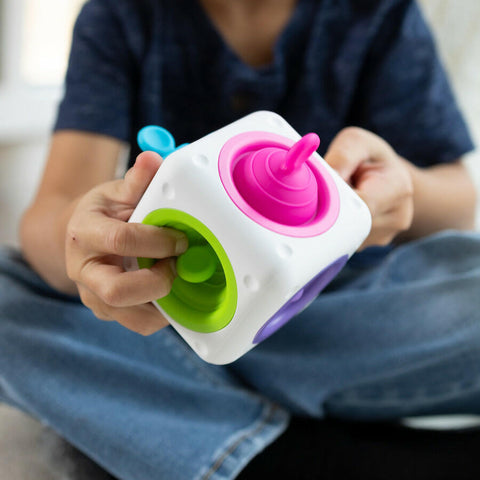 Child playing with the Fat Brain Tugl Cube silicone fidget