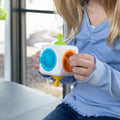 Child holding the colourful Fat Brain Tugl Cube