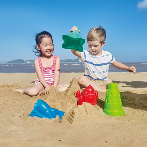Children playing on beach with Hape Sand toy Moulds