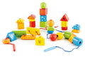 The Hape String-Along Shapes is a delightful assortment of colorful, geometric wooden blocks and beads with strings for threading. Perfect for enhancing cognitive skills and fine motor development, the set includes a variety of shapes such as triangles, rectangles, spheres, cylinders, and arches painted with intricate patterns and designs. The Hape logo proudly appears on one of the yellow blocks.