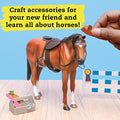 A person holds a small brown hat and comb in front of a toy horse with a saddle and reins. Next to the horse is a wooden box filled with mini grooming tools and a tiny carrot. Text above reads: "Craft accessories for your new friend, learn all about horse care, and enjoy our Klutz Wild About Horses model kit by KLUTZ!